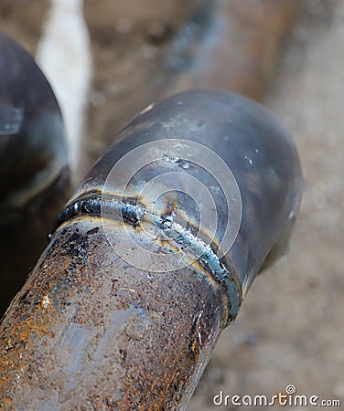 Closeup of a welded butt joint with some defects. Two metal pipes welded together Stock Photo