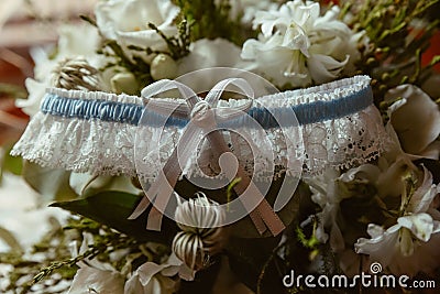 Closeup of a white and blue garter on a bouquet with blurred background Stock Photo