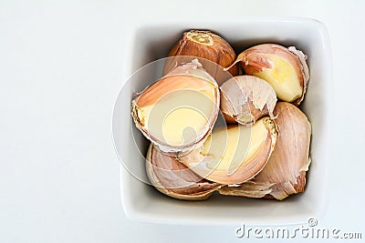 Closeup of a white bowl of pink garlic cloves Stock Photo