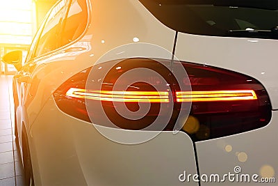 Closeup of white premium suv on a luxury indoor parking. Taillights, rear view mirrors, left side of a car Stock Photo