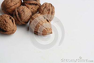 Closeup of whole walnuts under the lights on a white surface Stock Photo