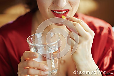 Closeup on woman with cup of water taking pill Stock Photo