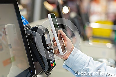Closeup Woman Counter Buy electronic payment supermarket smartphone Female hand with a mobile phone in pay for purchases Editorial Stock Photo