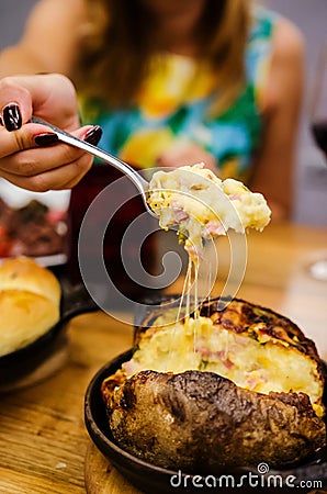 Closeup of woman eating baked potato Stock Photo