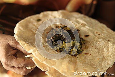 Closeup of woman eating South Indian north Karnataka peoples daily healhy breakfast Jowar roti or rotti or bhakri with dal curry Stock Photo