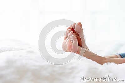 Closeup woman feet skin wearing jeans on white bed. Healthcare and health medical concept Stock Photo