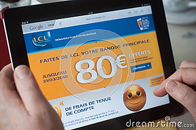 Closeup of woman hands on the credit Lyonnais french bank home page of web site on tablet Editorial Stock Photo