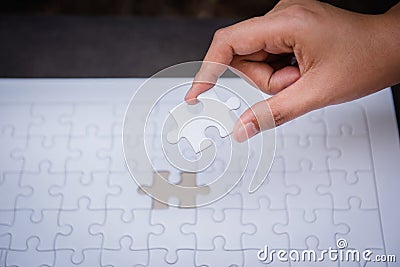 Closeup of woman hands fulfill the last piece of jigsaw puzzle t Stock Photo