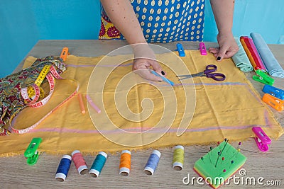 Closeup of woman hands sewing yellow cloth outdoors Stock Photo