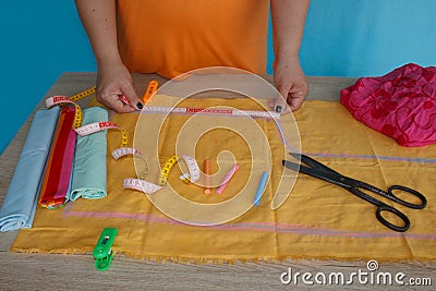Closeup of woman hands sewing yellow cloth outdoors Stock Photo