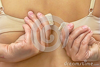 Female hands unfasten the bra Stock Photo