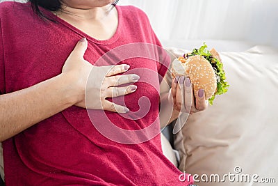 Woman having Gastroesophageal reflux disease after eating a burger Stock Photo