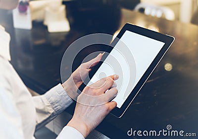 Closeup of a woman pointing finger to an blank display of the tablet with a blue color in a homelike atmosphere on warm bokeh back Stock Photo