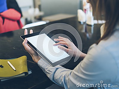 Closeup of a woman pointing finger to an blank display of the tablet with a blue color in a homelike atmosphere on warm bokeh back Stock Photo