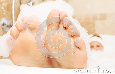 Closeup of woman`s feet covered with foam bubble bath Stock Photo