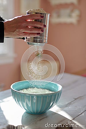 Closeup of woman sifting flour Stock Photo