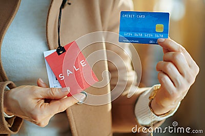 Closeup on woman trying beige coat with red sale price tag Stock Photo