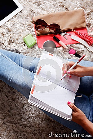 Closeup of a woman writing into her desk diary Stock Photo