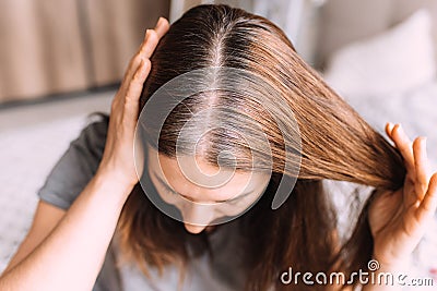 Closeup of a woman& x27;s head with parted gray hair regrown roots becouse of quarantine Stock Photo