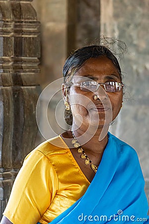 Closeup of woman in yellow-blue sare at Brahma Jinalaya temple, Lakkundi, Karnataka, India Editorial Stock Photo