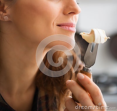 Closeup of womans mouth getting ready to eat piece of Camembert Stock Photo