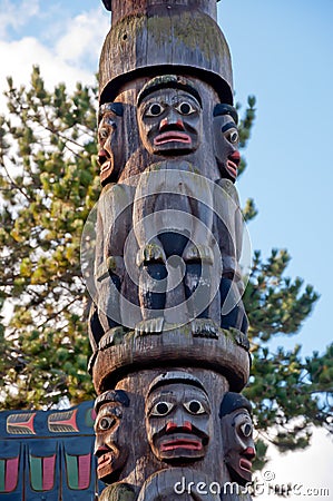 Closeup of wooden Totem poles in a park under the sunlight with a blurry background Stock Photo