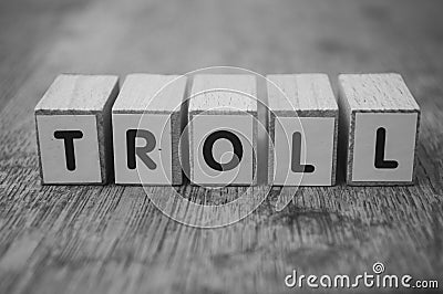 Wooden word on wooden table background concept - Troll Stock Photo