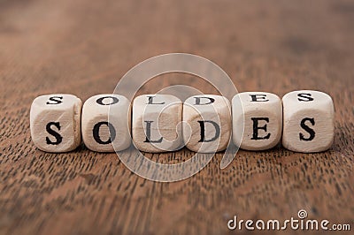 Word on wooden cube on wooden desk concept - soldes discount in french Stock Photo