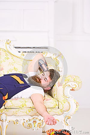 Closeup worker with stylish beard, mustache and tattoo on his arm sleeping on retro sofa. Tired mover having power nap Stock Photo