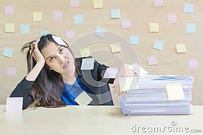 Closeup working woman are boring from pile of hard work and work paper in front of her in work concept on blurred wooden desk and Stock Photo