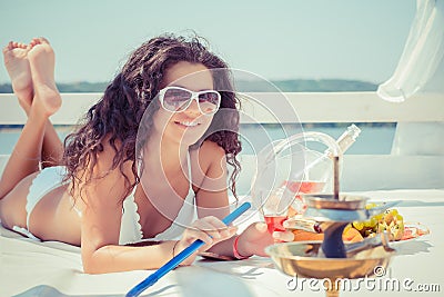Woman smiling happy holding champagne glass, smoking hookah Stock Photo
