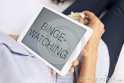 Man and tablet, with the text binge-watching in it Stock Photo