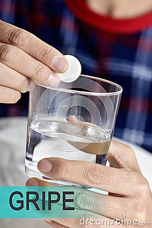 Text gripe, cold in spanish, and man taking a pill Stock Photo