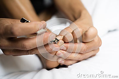 Young caucasian man cutting his toenails Stock Photo