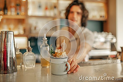 Bartender serving drinks behind the counter of a trendy bar Stock Photo