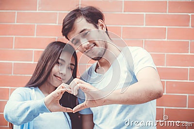 Closeup of young man and woman asian making heart shape with hand. Stock Photo