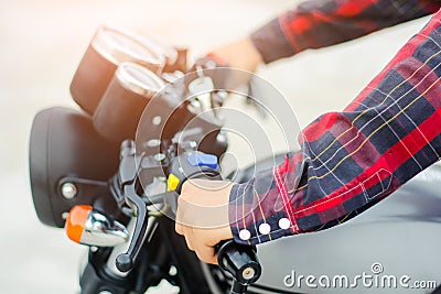 Closup hand men wear a red plaid shirt, Drive a vintage motorcycle. Stock Photo