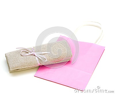 Cloth bundle and pink paper bag isolated on white Stock Photo