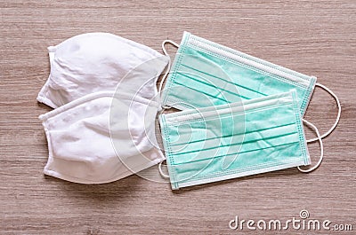 Cloth and surgical face masks for preventing covid-19 disease on wooden background Stock Photo