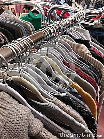 clothes hanging on hangers in used clothing store Stock Photo