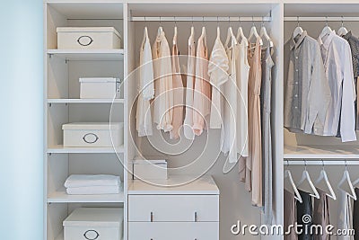 Clothes hanging on rail in white wardrobe Stock Photo