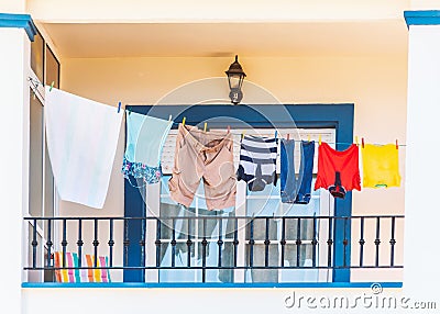 Clothes hanging on a washing line on a bright modern style blue and white balcony. Stock Photo