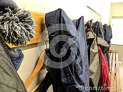 Clothes hung up on pegs in a changing room with coat hanger Stock Photo