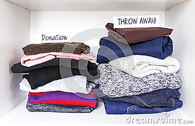 Clothes sorting in wardrobe on white shelf background. Donation, throw away paper notes Stock Photo