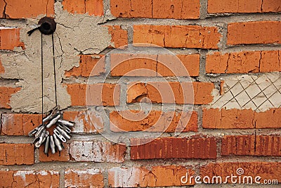 Clothespins for drying things hang on a rope on a nail against a brick wall Stock Photo