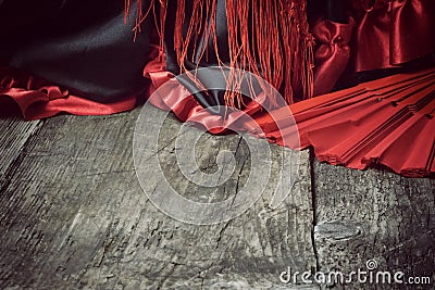 Clothing for Flamenco dance and red fan on the wooden desk. Stock Photo