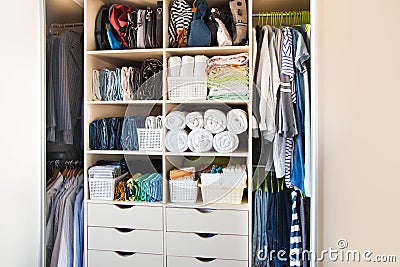 Clothing lying in the drawer in the wardrobe. T-shirts for women. The order in the wardrobe. Beige wardrobe Stock Photo