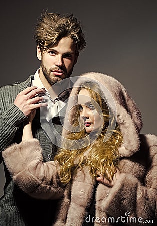 Clothing sale. Boyfriend hold hand of girlfriend in mink fur coat Stock Photo