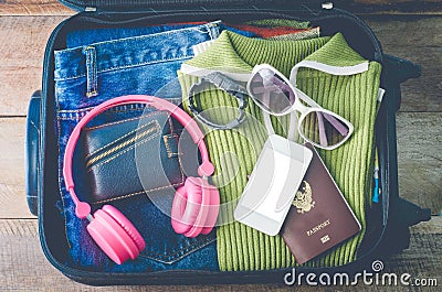 Clothing traveler`s Passport, wallet, glasses, watches, smart phone devices, on a wooden floor in the luggage ready to travel Stock Photo