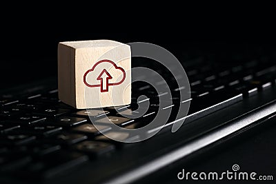 Cloud computing upload icon on wooden cube with computer keyboard. Remote download technology concept Stock Photo